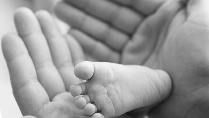 新生児の赤ちゃんの足と母親の手
