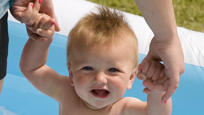日光浴がてらプールを楽しむ赤ちゃん