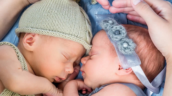 双子の新生児を守るママの手