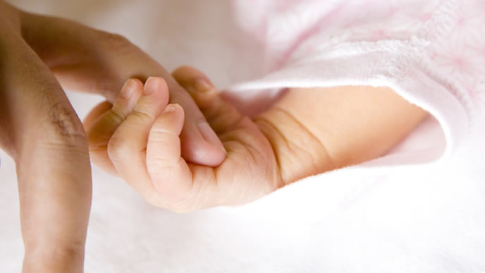 ママの指を握り安心する赤ちゃん