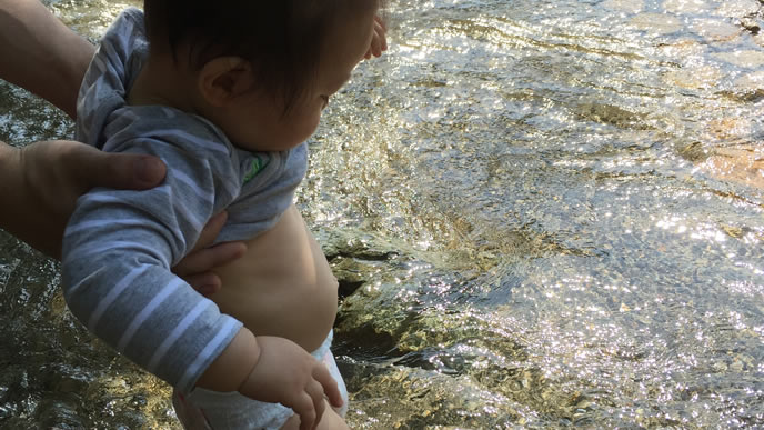 川の水に初めて触れる赤ちゃん