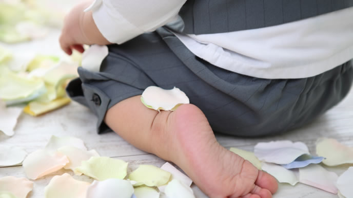 足の裏に花びらを乗っけている赤ちゃん