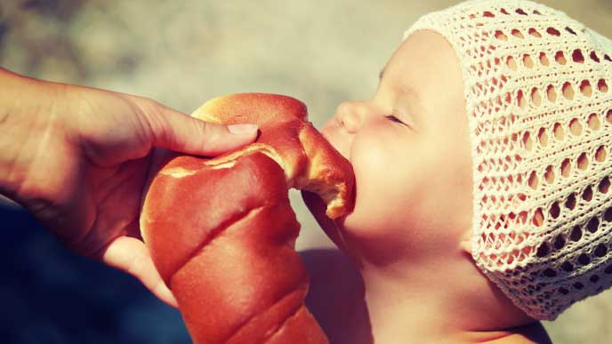 ロールパンを頬張る赤ちゃん
