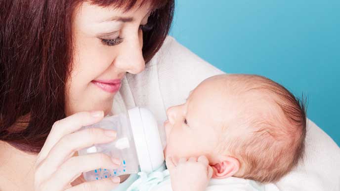 赤ちゃんに哺乳瓶でミルクをあげるママ