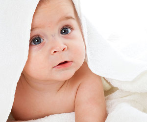 タオルを被る裸の赤ちゃん