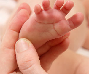赤ちゃんの足の裏を指で触る