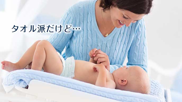 タオルを敷いて赤ちゃんを寝せる母親
