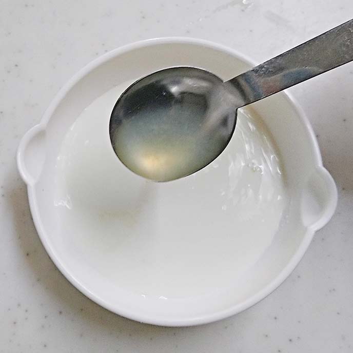 耐熱皿の中の牛乳とレモン汁の入ったスプーン