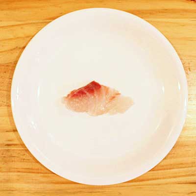 お皿にのった白身魚の刺身1つ