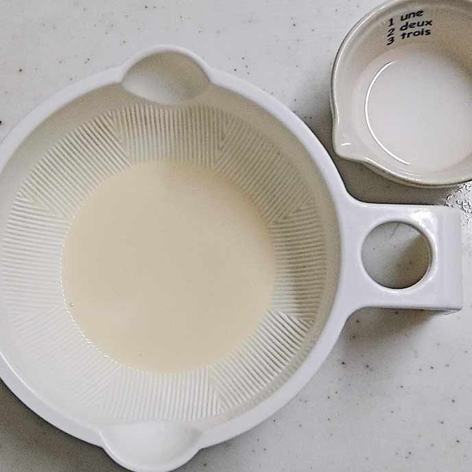 耐熱容器の中の豆乳とお皿の中の水溶き片栗粉