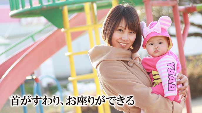 赤ちゃんを抱っこして公園を散歩する母親