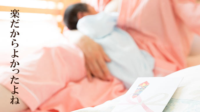 新生児を病院の寝台で抱く母親