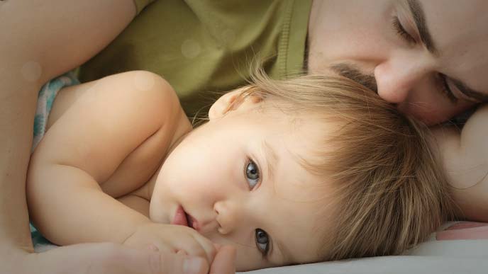 赤ちゃんを寝かしつけているうちに寝てしまった男性