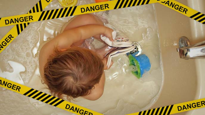 危険：水の少ないバスタブで遊ぶ赤ちゃん
