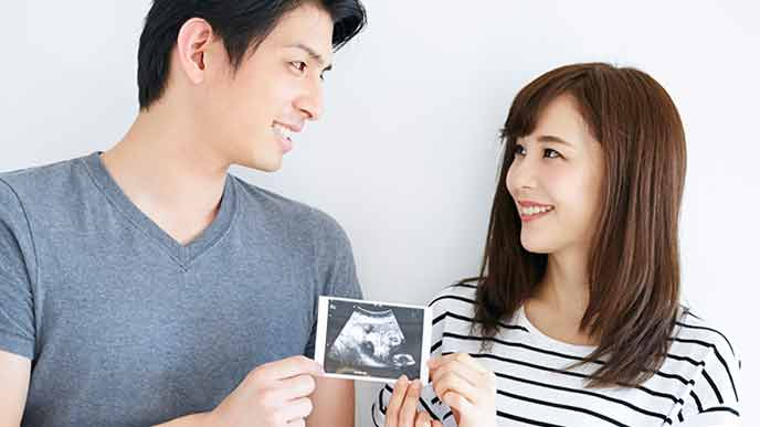 夫にエコー写真を見せる妻