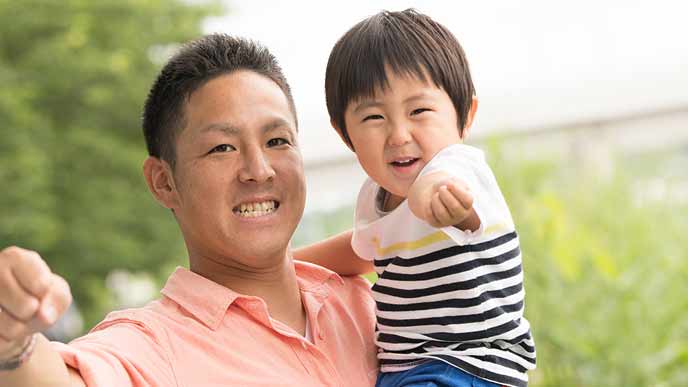 子供と外で遊ぶ父親