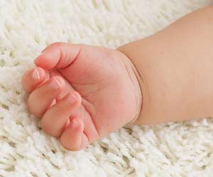 絨毯の上に赤ちゃん腕が伸びる