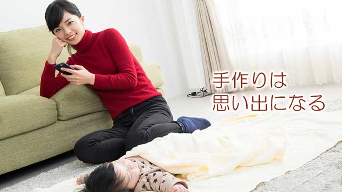 昼寝する赤ちゃんの傍でスマホを見る女性