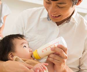 赤ちゃんにミルクを与える父親